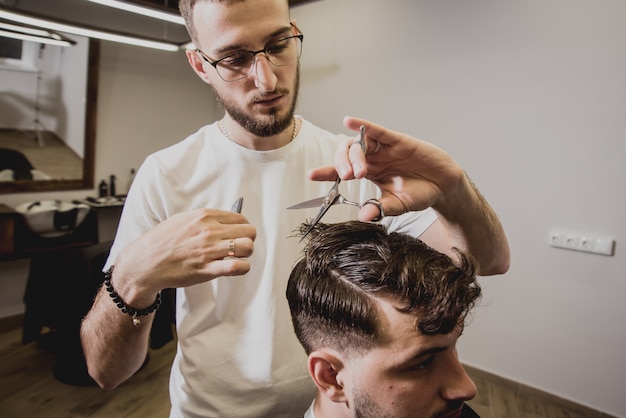 Young man with trendy haircut at barber shop.