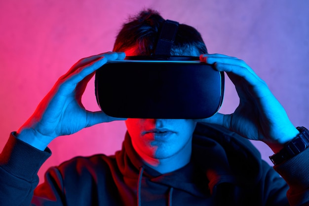Giovane con il casco di realtà virtuale che guarda l'obbiettivo