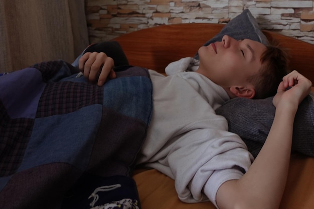 A young man with white hair is sleeping in his bed