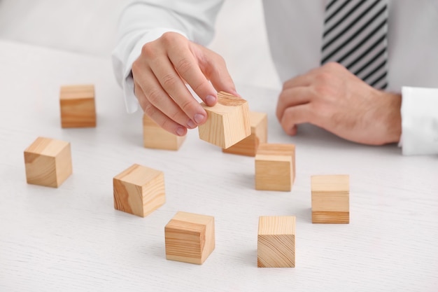 Young man with wooden cubes at table