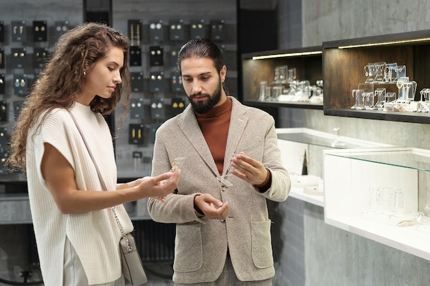Молодой мужчина и женщина консультируются по поводу ювелирных изделий в бутике