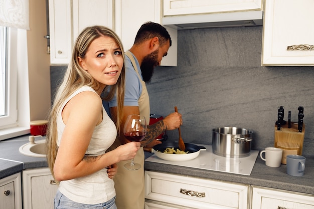 Giovane uomo e donna che cucinano cibo in cucina insieme coppia felice che prepara cibo