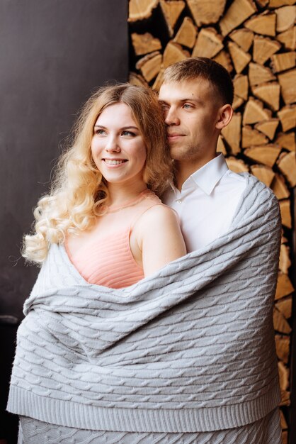 A young man and a woman embrace in a loft-style interior