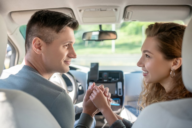 Young man and woman hand in hand looking at each other