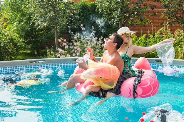 Young man and woman having fun while the environment is polluted, concept of problem plastic recycling, ecology and oceans pollution.