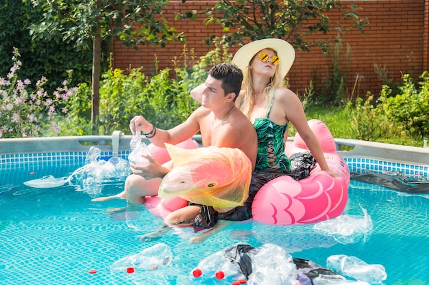 Young man and woman having fun while the environment is polluted, concept of problem plastic recycling, ecology and oceans pollution.