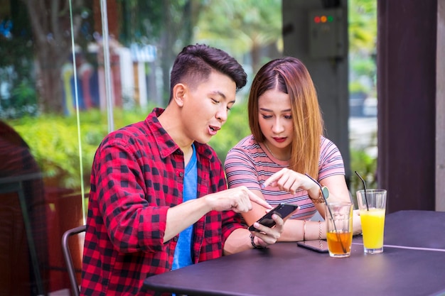 Young man and woman looking at cellphone together