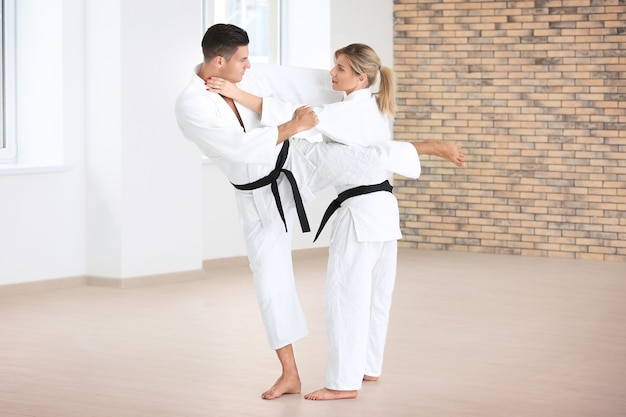 Giovane uomo e donna che praticano karate nel dojo