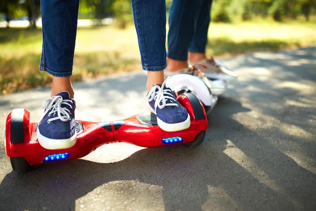 Young man and woman riding on the hoverboard in the park content technologies a new movement