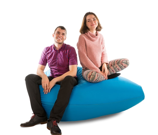 Young man and woman sitting on blue beanbag sofa for living room or other room isolated on white