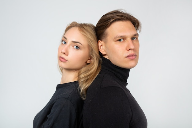 Photo young man and woman standing back to back