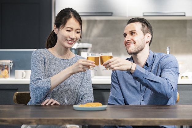 Young man and woman toasting with beer