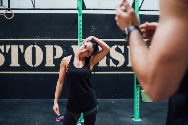 Photo young man and woman training together indoor gym