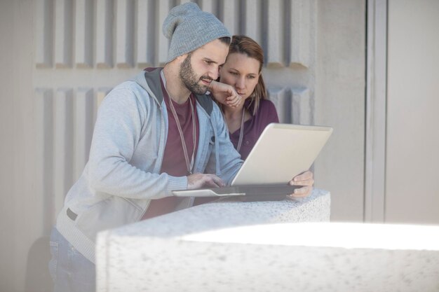 Young man and woman using laptop together
