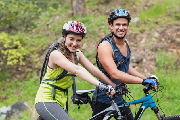 Young man and woman with bikers in forest