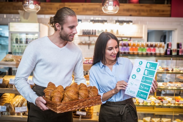 Young man and woman with croissants in a bakery