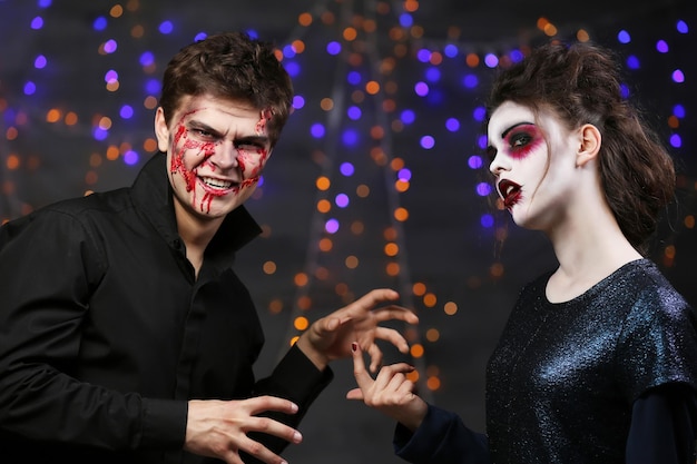 Young man and woman with Halloween makeup at party