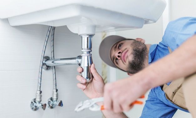 Young man worker in bathroom