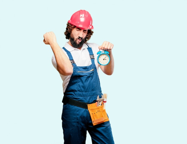 Young man worker with an alarm clock