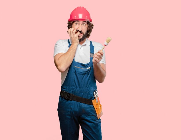 Young man worker with a paint brush