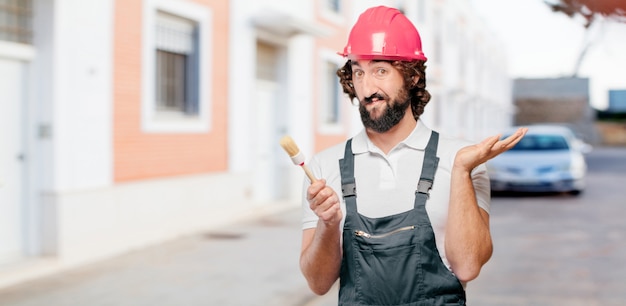 Young man worker with a paint brush