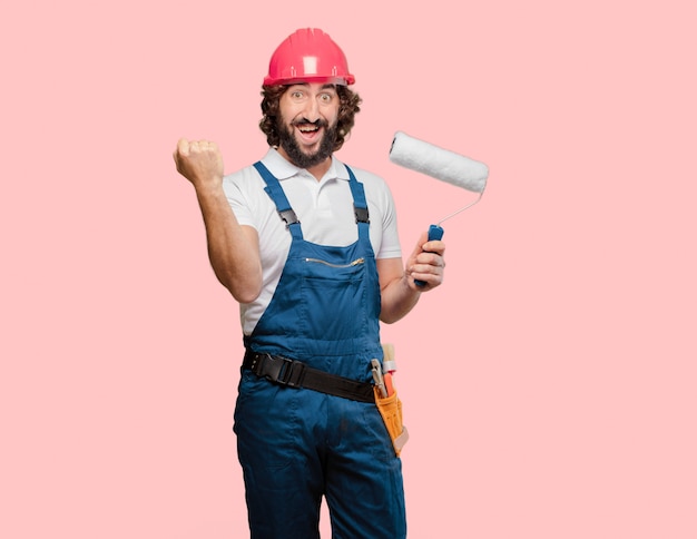 Young man worker with a paint roller