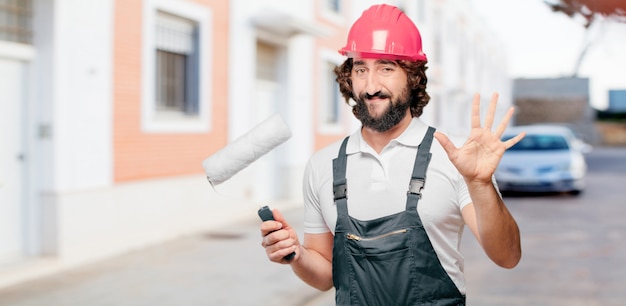 Young man worker with a paint roller