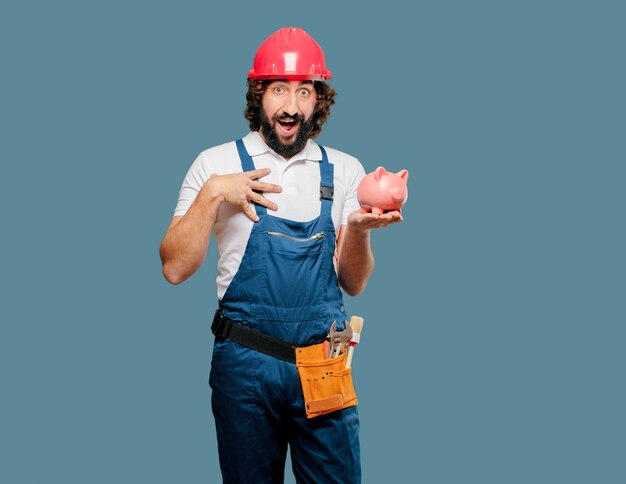 Young man worker with a piggy bank 