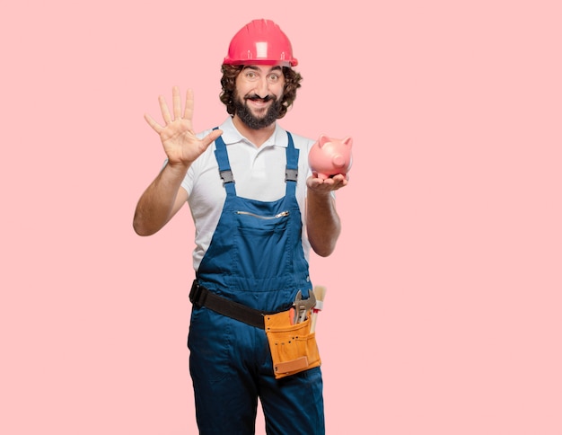 Young man worker with a piggy bank 