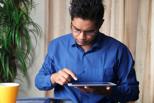 Photo young man working on digital tablet at office desk