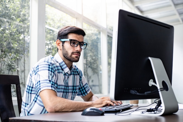 Young man working from home by computer.