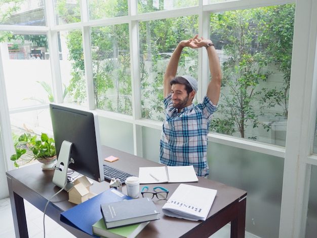 Young man working at home and Stretch  