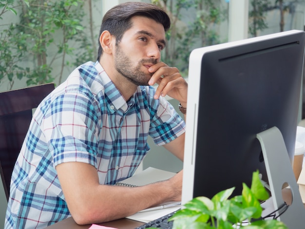 Young man working at home and thinking something 