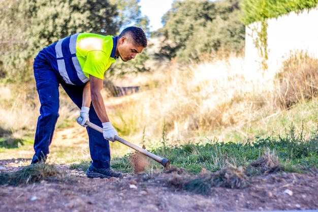 Young man working the land in his yard Person plowing the land in his yard