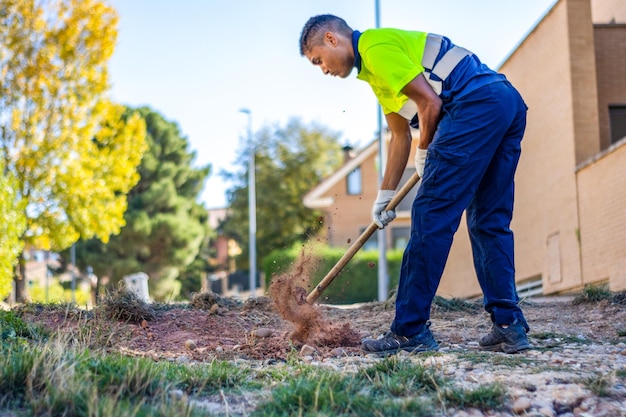 Young man working the land in his yard Person plowing the land in his yard