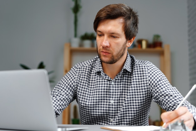 Young man working on laptop at his working table