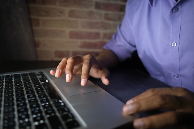 Young man working on laptop stealing personal data