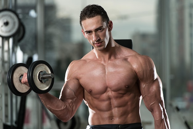 Young Man Working Out Biceps  Dumbbell Concentration Curls