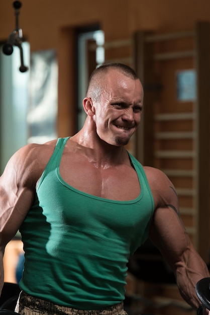 Young Man Working Out Biceps In A Health Club