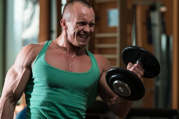 Young Man Working Out Biceps In A Health Club