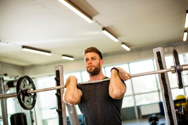 Young man working out with barbells in the gym