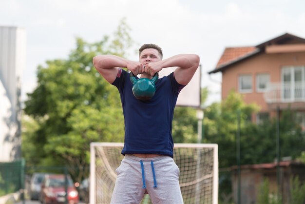 Young Man Working Out With Kettle Bell Exercise Outdoor