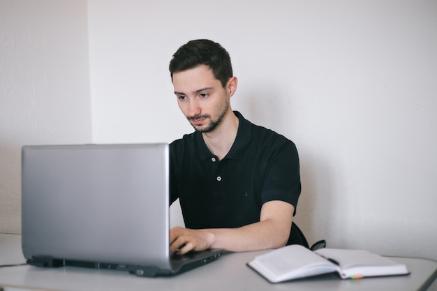 Photo young man working with a laptop