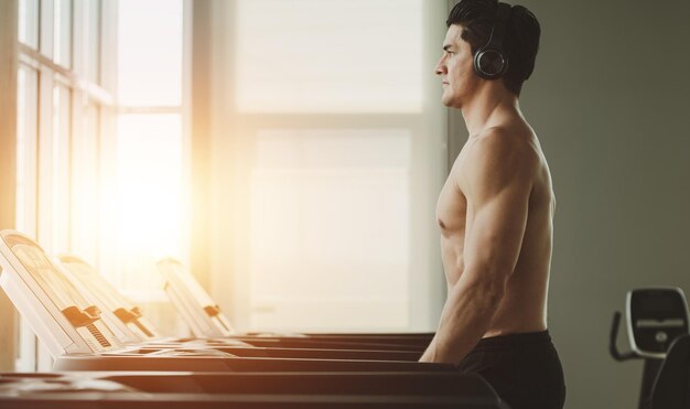 Young man in workout running on treadmill gym at home