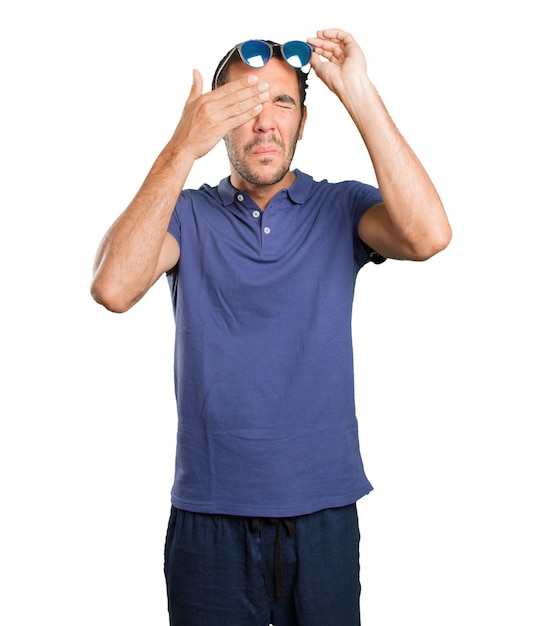 Photo young man worried about his sight on white background