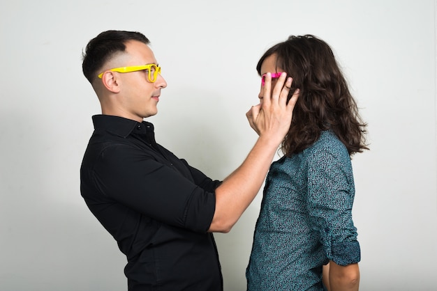  young man and young woman as couple together and in love against white wall