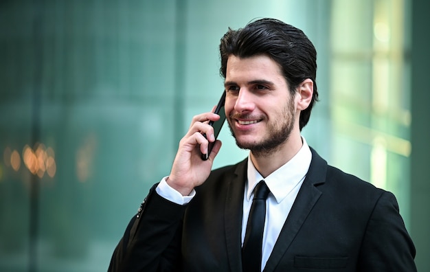 Young manager on the phone outdoor in an urban setting