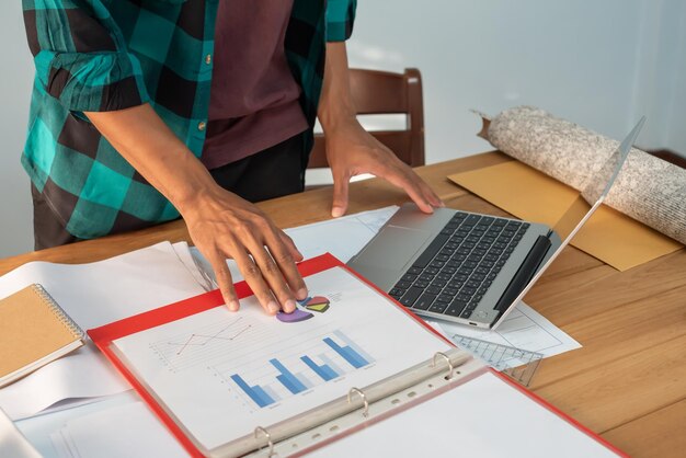 Foto giovane manager che utilizza un dispositivo computer portatile mentre è seduto al moderno concetto di processo di lavoro loft