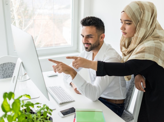 Young mand and woman working in office on computer