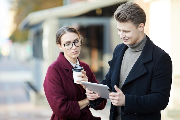 Young marketers analyzing app design on tablet